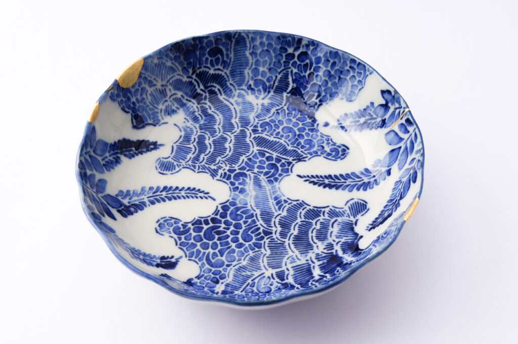 金継ぎで修復された青の文様が美しい陶器皿。繊細な絵付けと大胆な余白が余韻を残す和の器
